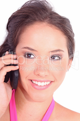 Beautiful young girl laying on a pillow chatting on a cell phone