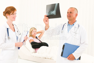 Medical doctors look x-ray patient broken arm