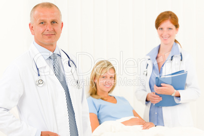 Medical doctors with hospital patient lying bed