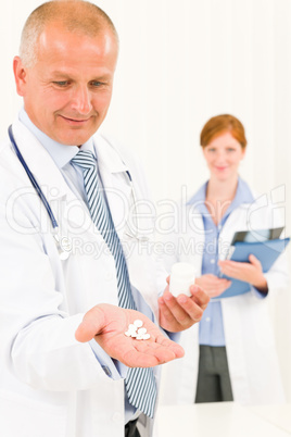 Medical doctor team senior male hold pills