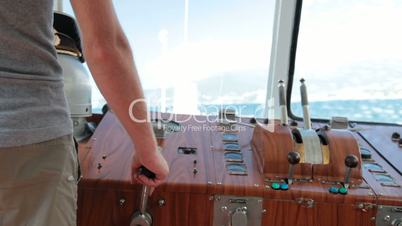 sailor controls boat in the wheelhouse