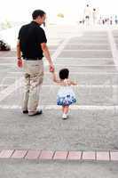 Baby walking like a model with her father