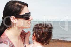 Mother and daughter enjoy hot summer weather at the beach.