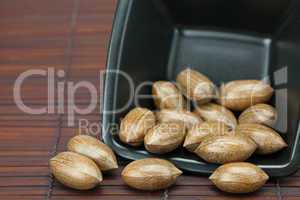 pecans in a bowl on a bamboo mat