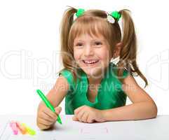 Cute little girl draws with markers