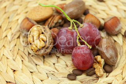 nuts and grapes on a wicker mat