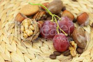 nuts and grapes on a wicker mat