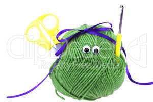 skein of wool with eyes, ribbon, scissors and crochet hooks isol