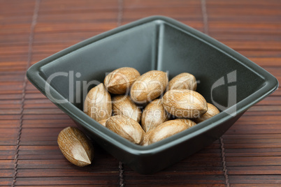 pecans in a bowl on a bamboo mat