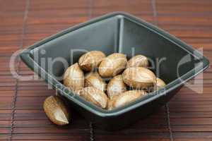 pecans in a bowl on a bamboo mat