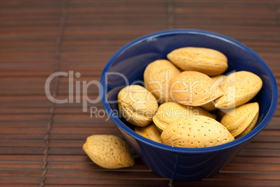 almonds in a bowl on a bamboo mat