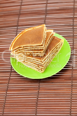 Pancakes on a plate on a bamboo mat