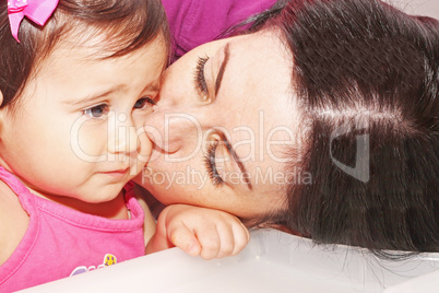 photo of a Mother kissing her daughter .