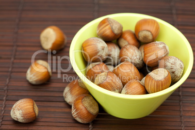 hazelnuts in a bowl on a bamboo mat