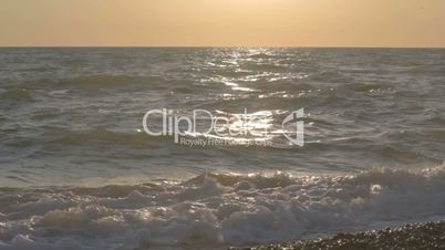 Sea waves with splashing away water at the sunset.