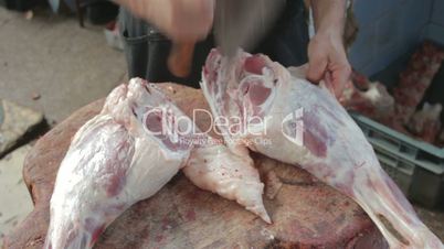 CLIP EDIT Butcher cutting leg of lamb on wooden frame