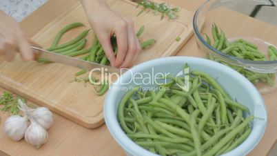 Cutting the remaining stems from fresh green beans outdoors