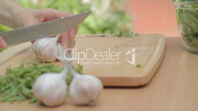 Dividing cloves of garlic with the help of knife outdoors