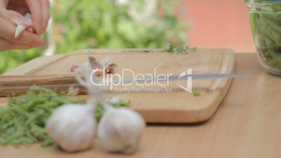 Shucking dry garlic cloves from skins on wooden board outdoors
