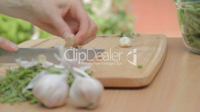 Cutting with knife garlic base and removing dry husks outdoors