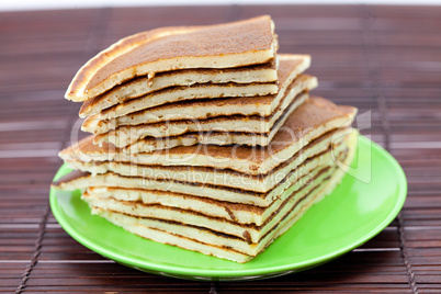 Pancakes on a plate on a bamboo mat