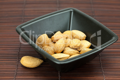 almonds in a bowl on a bamboo mat