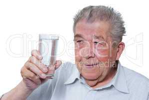 Senior hält ein Glas Wasser in der Hand
