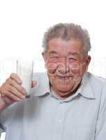 Senior hält glücklich ein Glas mit Milch in der Hand