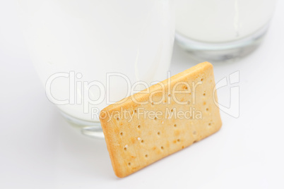 two glasses of milk and cookies on a gray background