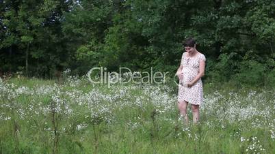 Pregnant woman dancing in the field
