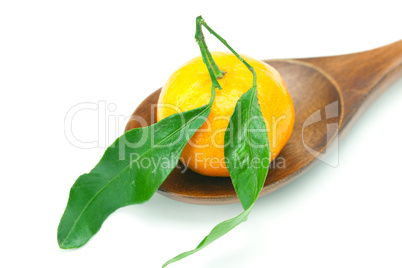 mandarin with green leaves on a wooden spoon isolated on white