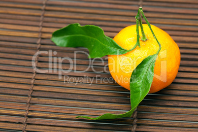 mandarin with green leaves on a bamboo mat