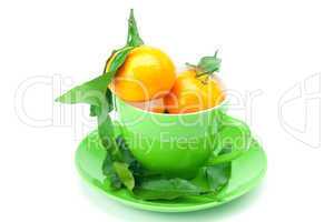 mandarin with green leaves in a cup isolated on white