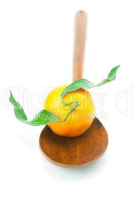 mandarin with green leaves on a wooden spoon isolated on white