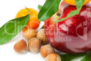 red apple, mandarin  with green leaves and nuts  isolated on whi