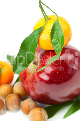 red apple, mandarin  with green leaves and nuts  isolated on whi