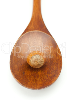 hazelnuts on a wooden spoon isolated on white