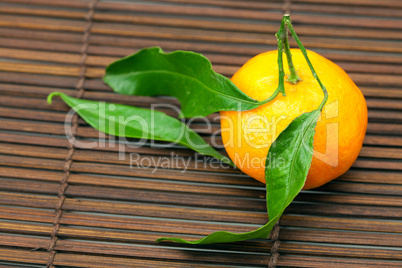 mandarin with green leaves on a bamboo mat