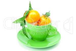 mandarin with green leaves in a cup isolated on white