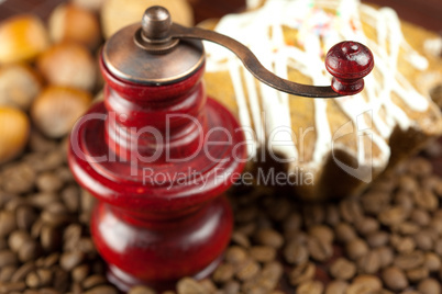 coffee grinder, cake with icing, nuts and coffee beans on a bamb