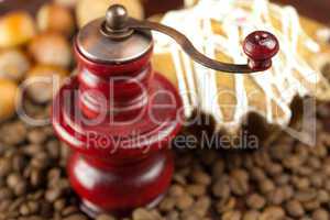 coffee grinder, cake with icing, nuts and coffee beans on a bamb