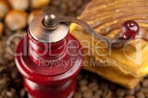 coffee grinder,  cake with chocolate, nuts and coffee beans on a