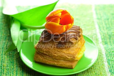 cake with chocolate and tulips on a plate on the fabric