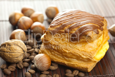 cake with chocolate, coffee beans and nuts lying on a bamboo mat