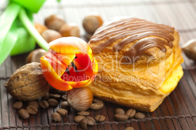 cake with chocolate, coffee bean, tulip and nuts lying on a bamb