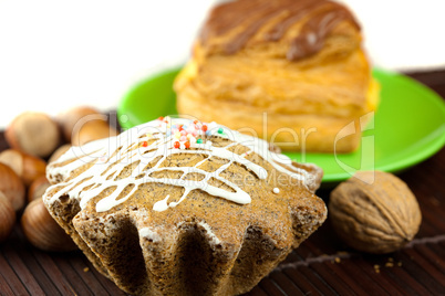 cake with icing, cake with chocolate and nuts lying on a bamboo