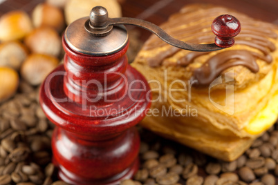 coffee grinder,  cake with chocolate, nuts and coffee beans on a