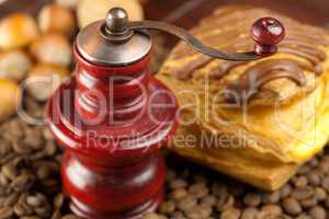 coffee grinder,  cake with chocolate, nuts and coffee beans on a