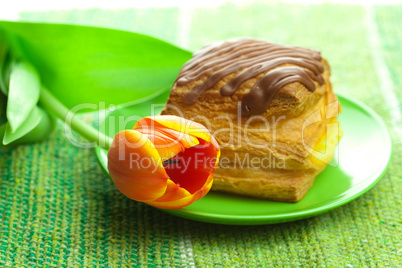 cake with chocolate and tulips on a plate on the fabric
