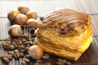 cake with chocolate, coffee beans and nuts lying on a bamboo mat